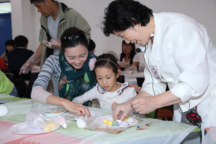 Visitors make half-moon-shaped rice cakes at the NFMK (photo courtesy of NFMK). 