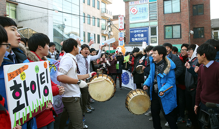 Younger high school students gather in front of the CSAT test venue and cheer on students from other high schools on the morning of November 13.