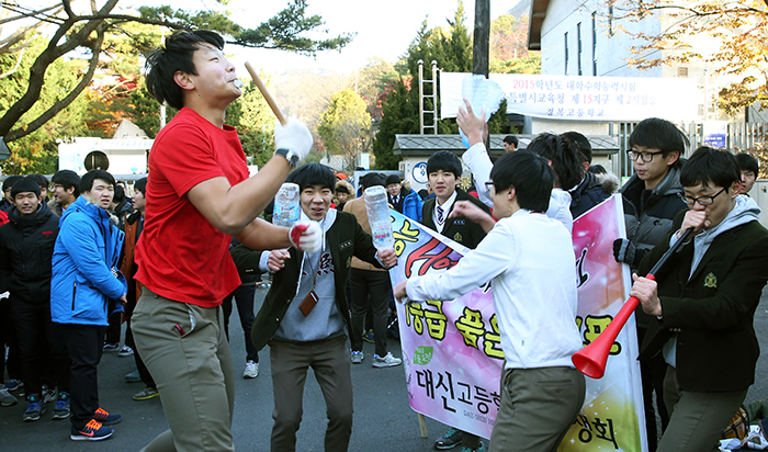 Younger students from Daeshin High School cheer and chant for their older schoolmates who take the CSAT on November 13.