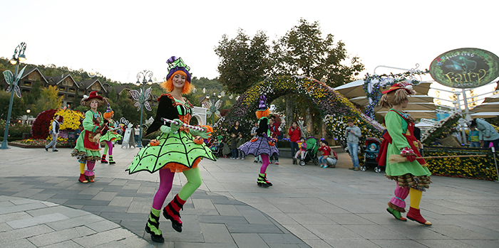 Fairies and mascots dance along in the Happy Halloween Party parade.