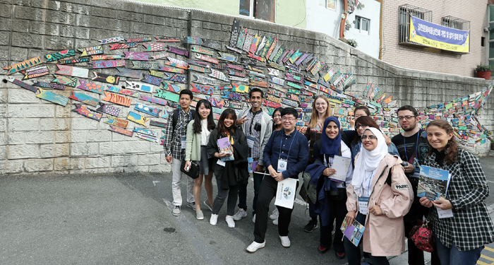 Korea.net honorary reporters pose for a commemorative photo in front of the ‘Fish Travels the Alleys’ mural by artist Jin Yeong-seop, at the Gamcheon Culture Village in Saha-gu District, Busan, on Oct. 26.