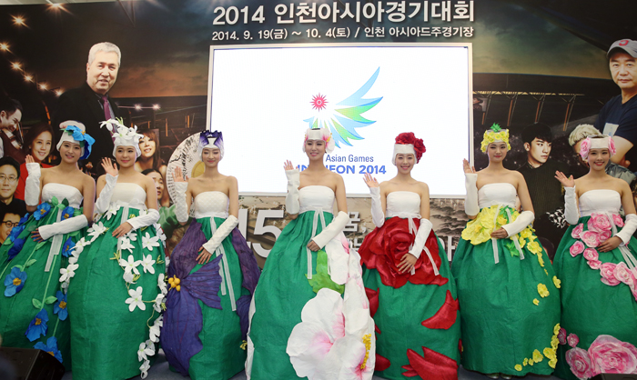 Models clad in their outfits for the Incheon Asian Games 2014 opening and closing ceremonies wave to the audience.