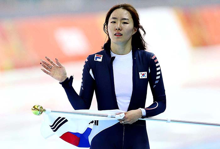 Lee Sang-hwa waves her hand to the crowd while holding the Taegeukgi, the Korean flag, after winning the ladies 500-meter race with a new Olympic record of 37.28 seconds. (photo courtesy of the Korean Olympic Committee)