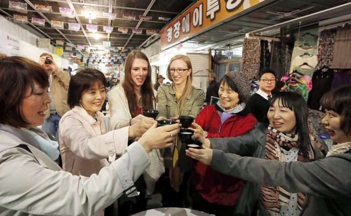 Participants in the <i>makgeolli</i>-tasting event at Gwangjang Market offer up a toast on April 10. (photo: Jeon Han) 