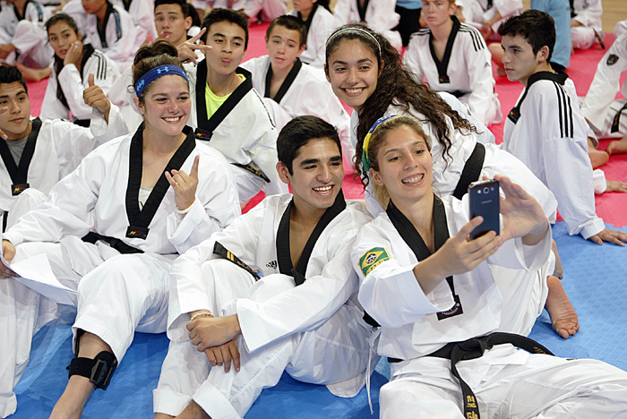 Taekwondo practitioners from around the world, all dressed in their uniform, take selfies after their set of training programs at the Taekwondowon in Muju, Jeollabuk-do. 