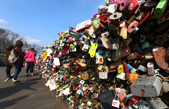 Tens of thousands of “love locks” are hung on the railing of the terrace at the base of the N Seoul Tower. Tourists are flocking here to the place their own padlock, as featured in “My Love From the Star.” (photo: Jeon Han) 