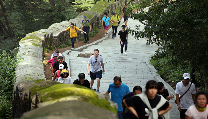 Plelchach (center) catches his breath while climbing up the fortress path of Namsan Mountain during the Turtle Marathon on August 24. (photo: Jeon Han)