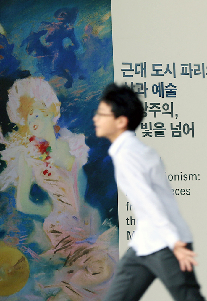  A visitor passes by a poster for the Impressionist exhibition that will continue until the end of August. (photo: Jeon Han) 