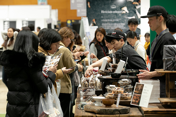 Visitors to the “Korean Dessert Table” look around various kinds of gangjeong fried glutinous nut crackers on Nov. 28.