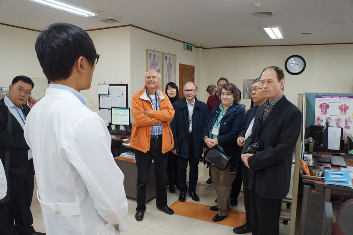 Workshop participants talk with a staff member at an Oriental medicine hospital in Korea. 
