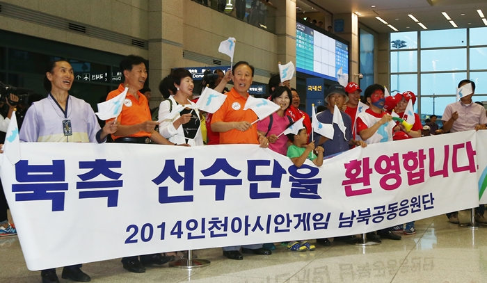 Members of the 'North and South joint cheering squad' wave the flag of the Korean Peninsula as the North Korean athletes arrive at Incheon International Airport on the afternoon of September 11.