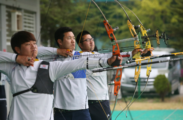 From left: South Korean archers Lee Seung-yun, Ku Bon-chan and Kim Woo-jin take aims during practice at the National Training Center in Seoul on April 22, 2016. (Yonhap)
