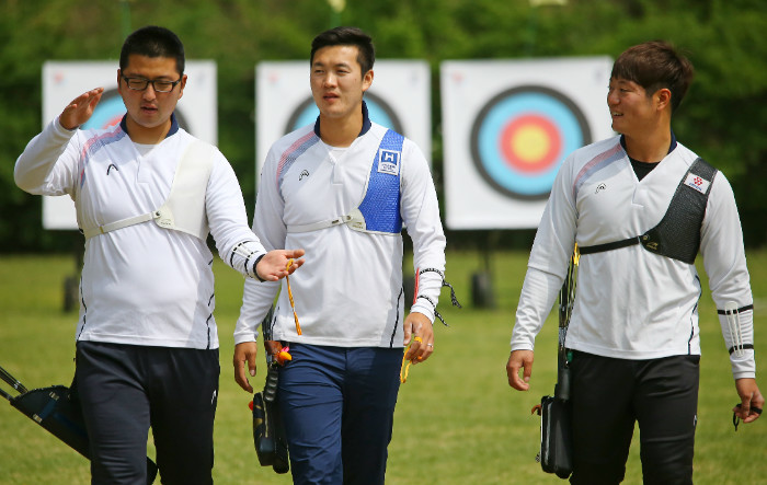 From left: South Korean archers Kim Woo-jin, Ku Bon-chan and Lee Seung-yun walk back from their targets during practice at the National Training Center in Seoul on April 28, 2016. (Yonhap)