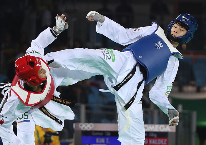 South Korea's Kim Tae-hun (R) lands a kick on Carlos Navarro of Mexico in the men's -58kg taekwondo bronze medal match at the Rio de Janeiro Olympics on Aug. 17, 2016. (Yonhap)