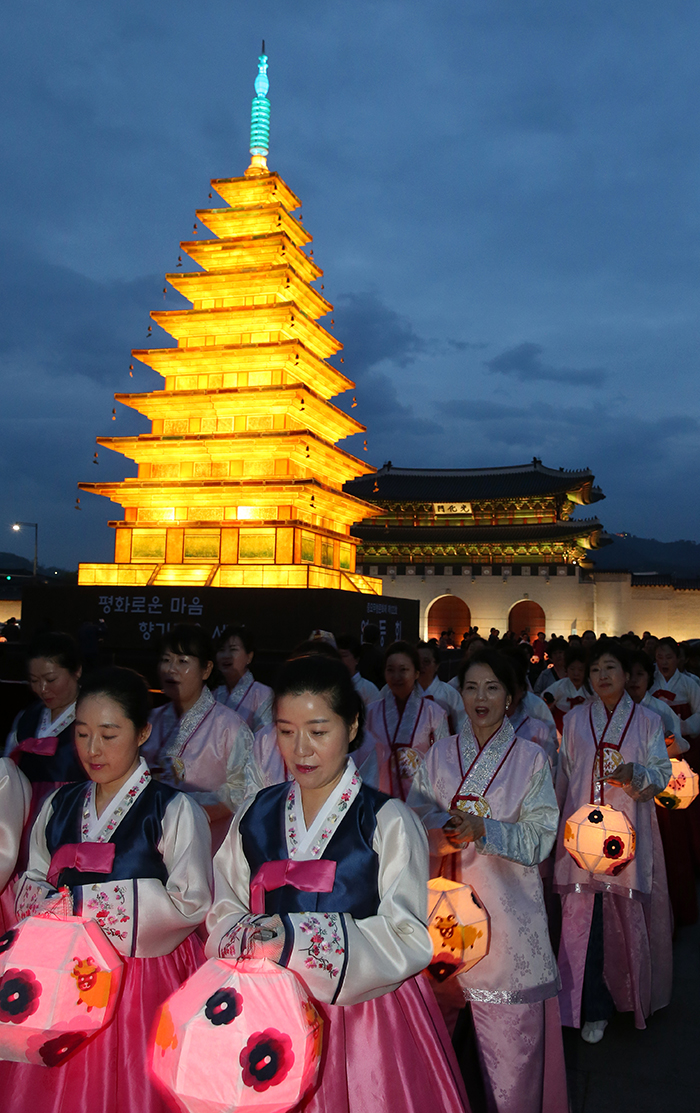 Religious Buddhists hold lotus lanterns as they walk around the pagoda-shaped lantern and pray on April 29.