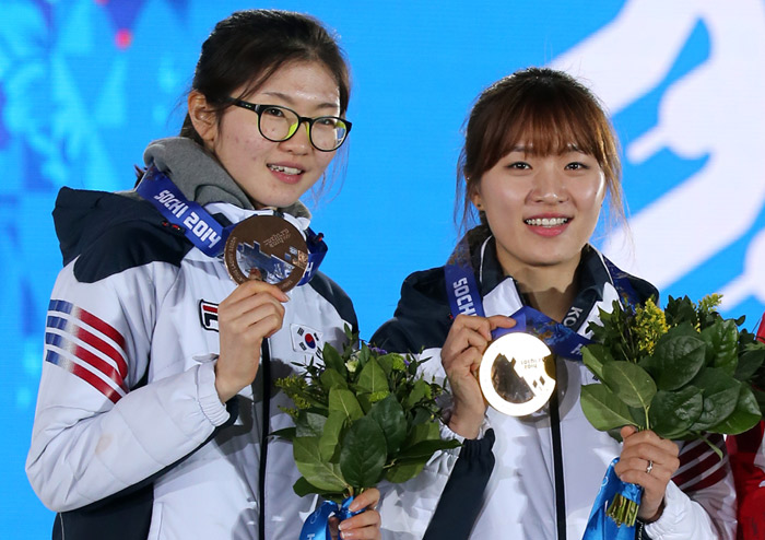 Park Seung-hi (right) and Shim Suk-hee pose for photos during the award ceremony on February 23 at the Sochi Medals Plaza after finishing the ladies’ 1,000-meter short track race. Park won gold and Shim won bronze. (photo: Yonhap News)