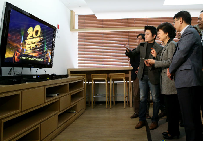 President Park (second from right) tries a smart set-top box during her visit to Alticast, a broadcasting software firm in southern Seoul, on March 12 (photo courtesy of Cheong Wa Dae).