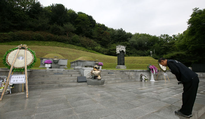 A citizen pays silent tribute in front of the graves of former President Park Chung-hee and his spouse Yuk Young-soo.