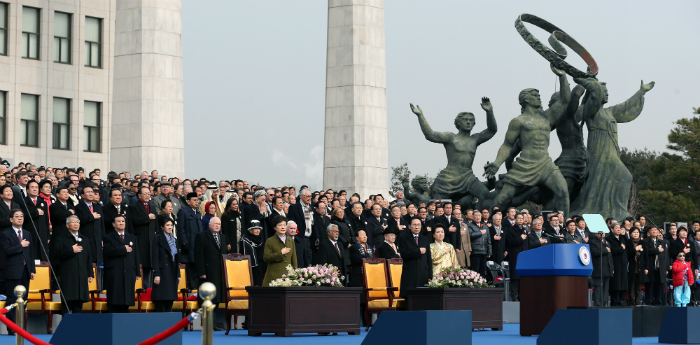 President Park Geun-hye, former President Lee Myung-bak, and other participants of the inauguration salute the national flag at the presidential inauguration ceremony held at the National Assembly in Seoul on February 25 (National Assembly = Jeon Han).