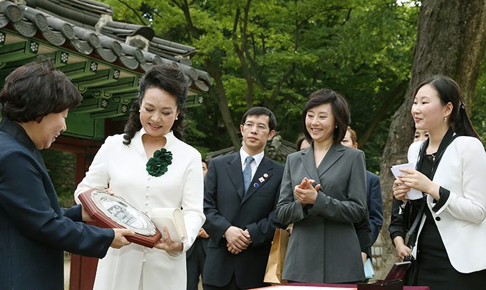 Administrator Rha Sun-hwa (left) of the Cultural Heritage Administration of Korea presents a plaque engraved with Buyongjeong Pavilion to Chinese First Lady Peng Liyuan (second from left), at Changdeokgung Palace, on July 3. (photo: Jeon Han)