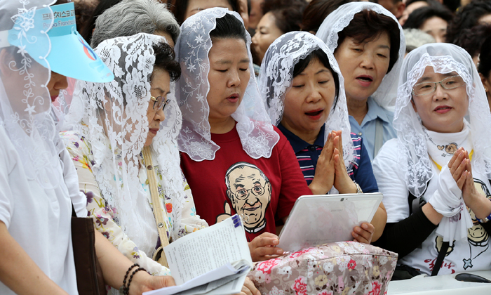 Roman Catholics welcome Pope Francis outside the Myeongdong Cathedral even though they were not able to attend the Mass. 