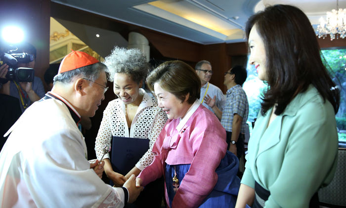 Archbishop of Seoul and Cardinal of Korea Andrew Yeom Soo-jung (left) shakes hands with PR ambassadors for the papal visit, during a blessing ceremony on August 13. The PR ambassadors are singer Insooni (second from left), actress Kim Hae-sook (third from left) and Chae Shi-ra (fourth from left). (photo: Jeon Han)