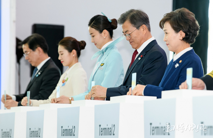 President Moon Jae-in (second from right) and Minister of Land, Infrastructure and Transport Kim Hyun-mee (right) insert tickets into machines, alongside some airline employees, to celebrate the opening of the second terminal at Incheon International Airport, in Incheon on Jan. 12. (Hyoja-dong Studio)
