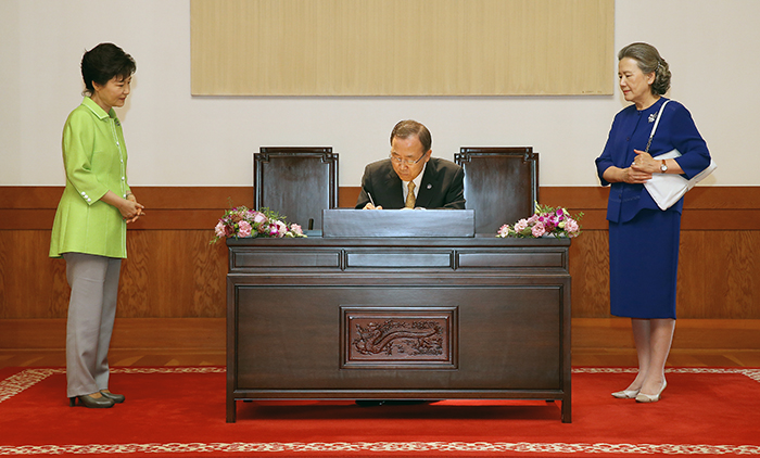 UN Secretary General Ban Ki-moon writes in the guestbook with President Park Geun-hye (left) and his spouse present (photo: Cheong Wa Dae).