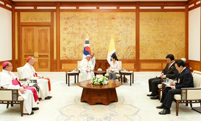 Pope Francis and President Park Geun-hye (top) shake hands at Cheong Wa Dae on August 14. Pope Francis and his entourage talk to President Park Geun-hye. (photo: Cheong Wa Dae)