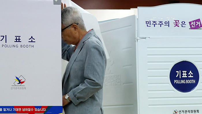A voter casts his ballot inside a voting booth at a polling station at the library at Hongeun Middle School in Seodaemun-gu District, Seoul, on the presidential election day of May 9.