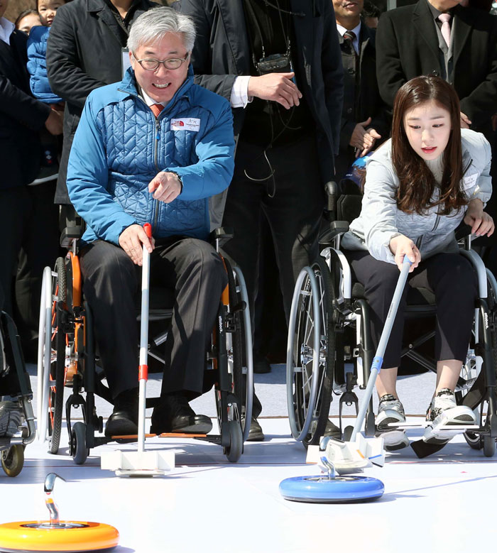 Minister of Culture, Sports and Tourism Kim Jongdeok (left) and Kim Yu-na, a PR ambassador for the PyeongChang Winter Olympics, play wheelchair curling during a promotional event for the 2018 PyeongChang Paralympics, in Gwanghwamun Square, central Seoul, on March 14.