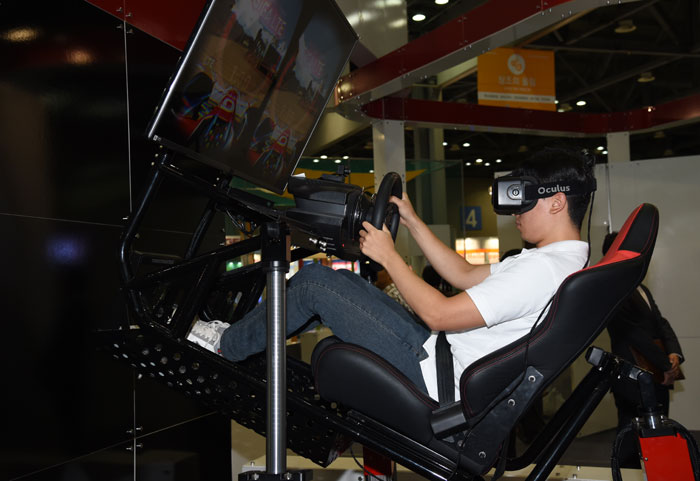 A visitor races a car in virtual reality. 