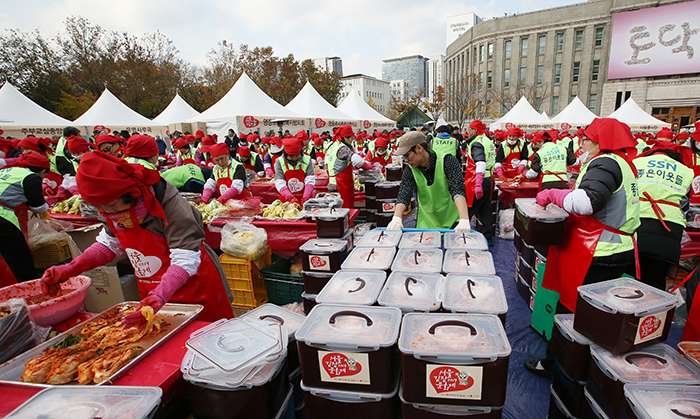 A volunteer moves crates of kimchi being churned out by festival participants during the 2014 Seoul Kimchi Making & Sharing Festival on November 14. All kimchi made during the event was donated to charity and to families in need. 
