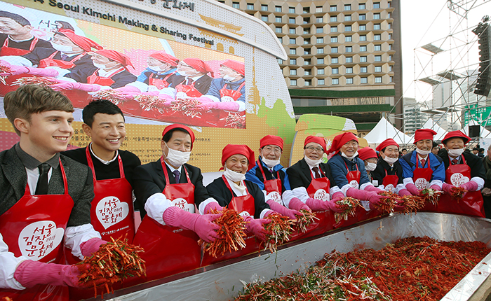Minister of Agriculture, Food & Rural Affairs Lee Dong-phil (sixth from left), Seoul Mayor Park Won-soon (fifth from left), Gwangju Mayor Yoon Jang-hyun (fourth from left) and other participants mix kimchi seasoning during the opening ceremony of the 2014 Seoul Kimchi Making & Sharing Festival on November 14.