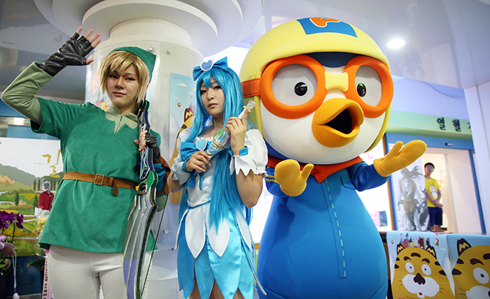 Actors dressed like comic book and cartoon characters greet visitors at SICAF 2014. In the above photo, famous cartoon character Pororo (right) and actors dressed like comic book characters pose for a photo. (photo: Jeon Han)