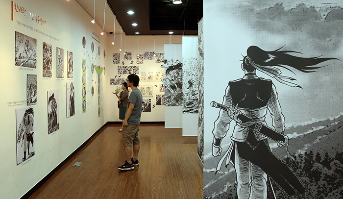 Visitors stroll through the special exhibition to mark the 20th anniversary of the comic book 'Ruler of the Land' during the opening ceremony of SICAF 2014 on July 22. (photo: Jeon Han)