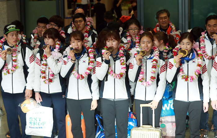 Korean national athletes pose for a photo wearing the chocolate medals received from the Korean Olympic Committee at Incheon International Airport on February 25, returning home after the 2014 Sochi Winter Olympic Games. (photo: Yonhap News)