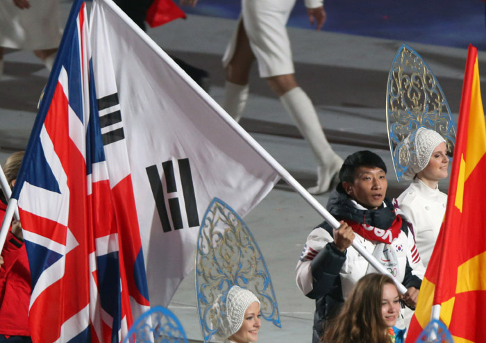 Korean speed skater Lee Kyu-hyuk, as the flag bearer representing Korea, marches into the stadium holding the Taegeukgi during the closing ceremony of the 2014 Sochi Winter Olympic Games on February 23. (photo: Yonhap News) 