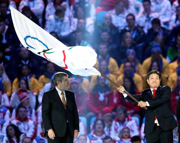 Lee Seok-rae (right), mayor of Pyeongchang, waves the Olympic flag upon receiving it from Olympic President Thomas Bach (left) of the International Olympic Committee. (photo courtesy of the Korean Olympic Committee) 
