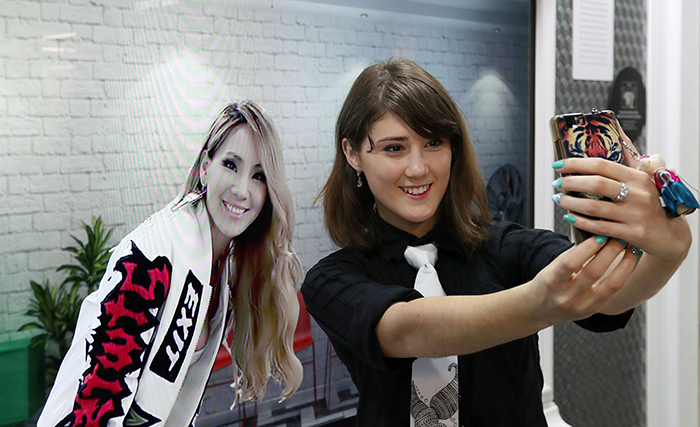 Tikhonova Anastasia from Moldova takes a selfie with the image of a K-pop star at the K-Style Hub on Oct. 19. She won the top prize in the video category.