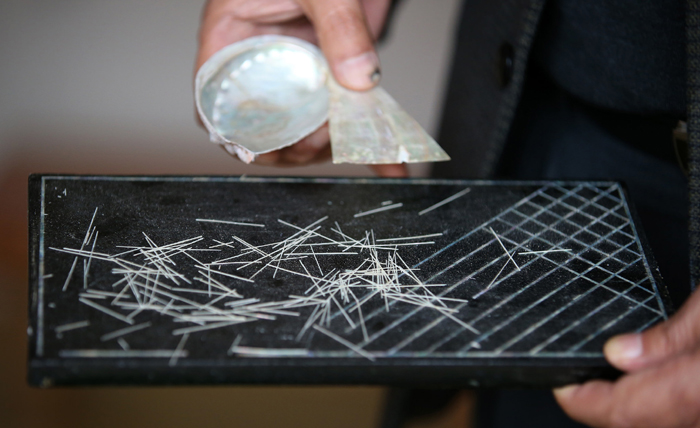 A master turns hair-like thin mother-of-pearl strips, made from abalone shells caught just offshore, into works of art at one of the 12 restored traditional workshops in Tongyeong, Gyeongsangnam-do. 