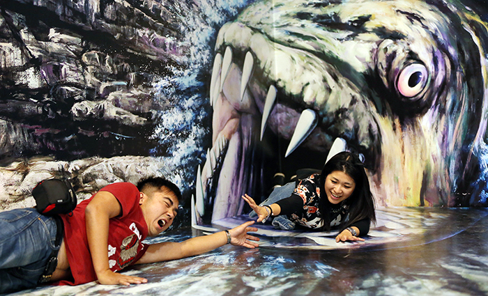 Rainbow (right), visiting the museum from Hong Kong with her friend, poses for a picture in front of a giant, man-eating fish. (photo: Jeon Han)