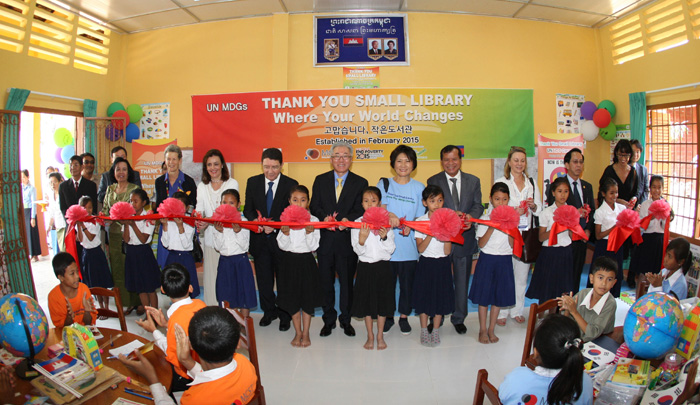 Minister Kim Jongdeok cuts the ribbon with other participants in the opening ceremony for a new Small Library at Kessaram Elementary School in Siem Reap on February 5.