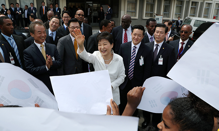 President Park Geun-hye waves to Ethiopian children with Korean flags as she leaves Addis Ababa University after appreciating the K-culture in Ethiopia' on May 28.