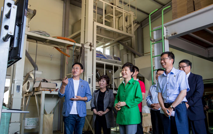 President Park Geun-hye (second from right, front row) and staff of a local food outlet in Gimpo, Gyeonggi Province, look around automation facilities on July 11. (photo: Cheong Wa Dae)