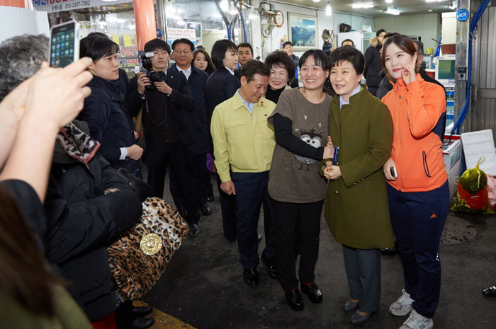 President Park Geun-hye (second from right) poses for a photo with some shop owners at Daein Market in Gwangju on January 27.