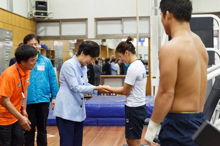 President Park Geun-hye (third from left) holds the hands of Korean wrestler Lee Yumi at the Korea National Training Center in Taeneung, Seoul, on August 25. (photo: Cheong Wa Dae)