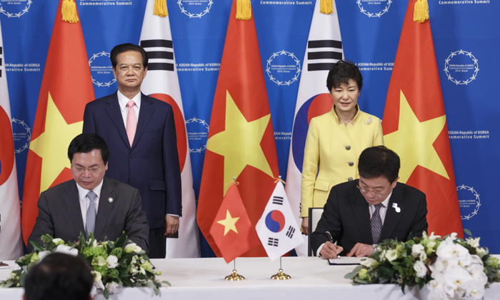 President Park Geun-hye (back, right) and Vietnamese Prime Minister Nguyen Tan Dung (back, left) watch as Korean Minister of Trade, Industry and Energy Yoon Sang-jick (front, right) and his Vietnamese counterpart Vu Huy Hoang sign an FTA agreement between Korea and Vietnam on December 10 in Busan. 