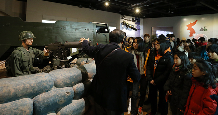 Students listen to an explanation about the weapons used during the Korean War while observing the diorama at the War Memorial of Korea. (Photo: Jeon Han)
