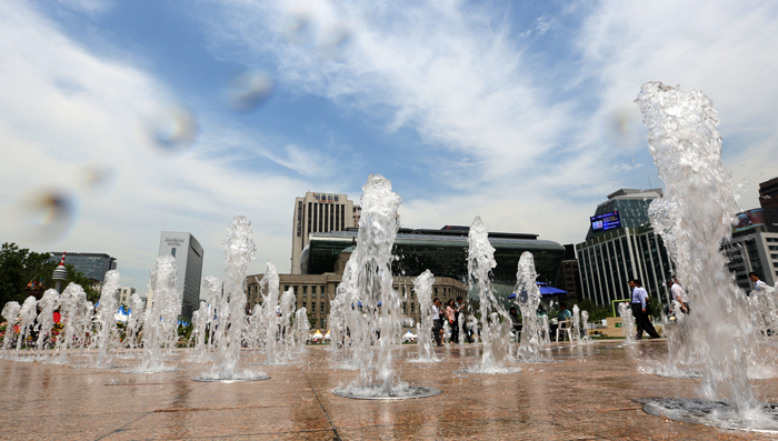 Streams of water spout from fountains at Seoul Plaza in downtown Seoul, offering respite from the hot temperature on May 31 (photo by Jeon Han).
